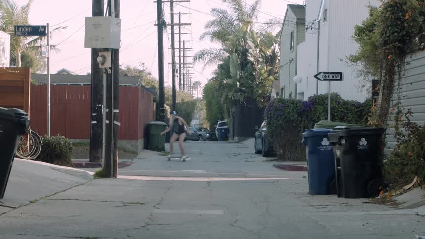 A woman skateboards down a street