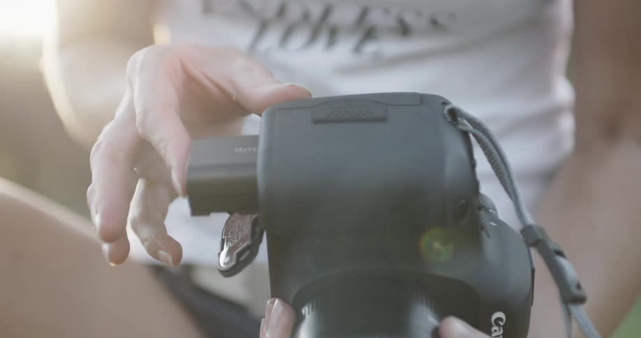Person loading a battery pack into their camera