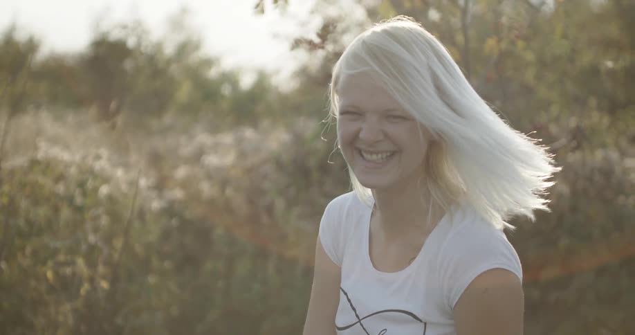 A light haired woman smiles and laughs