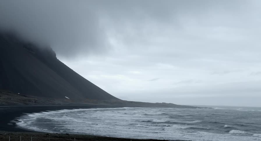 Waves coming ashore on a dark beach
