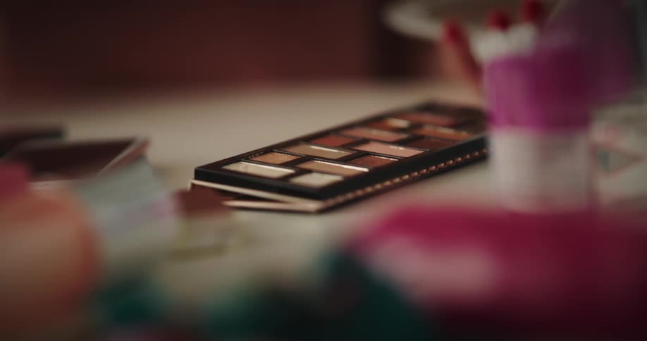 A person dips their brush in the makeup