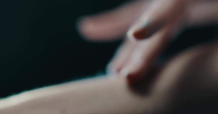 Close up of womans hand touching skin