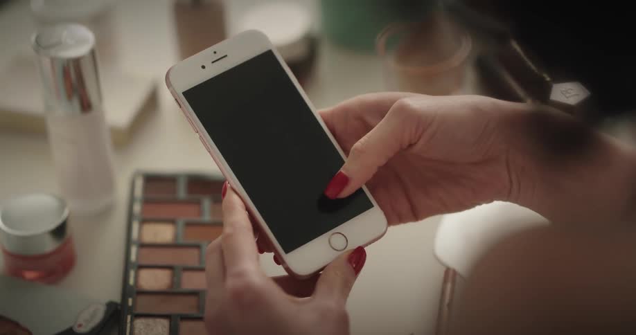 A woman is looking at a cellphone indoors