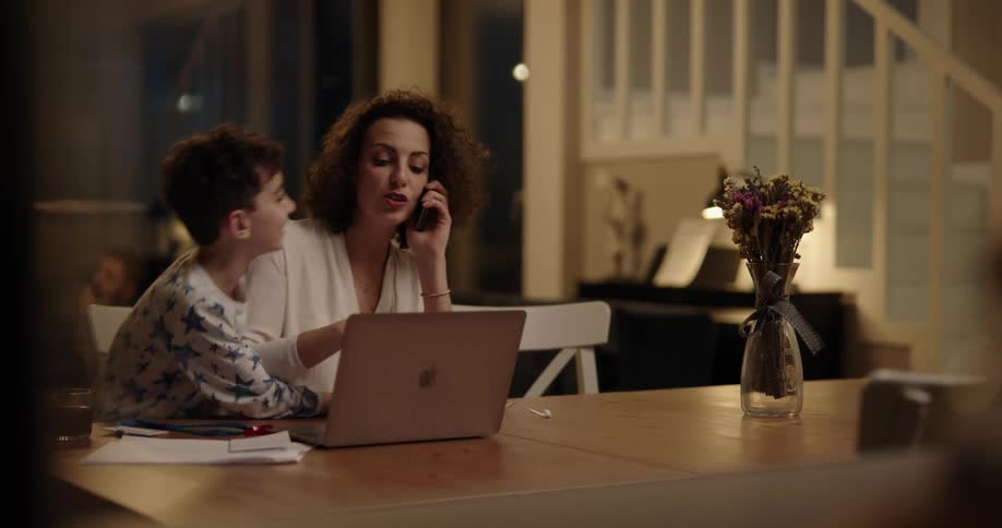 A young boy interrupting his mother on a phone conversation at home