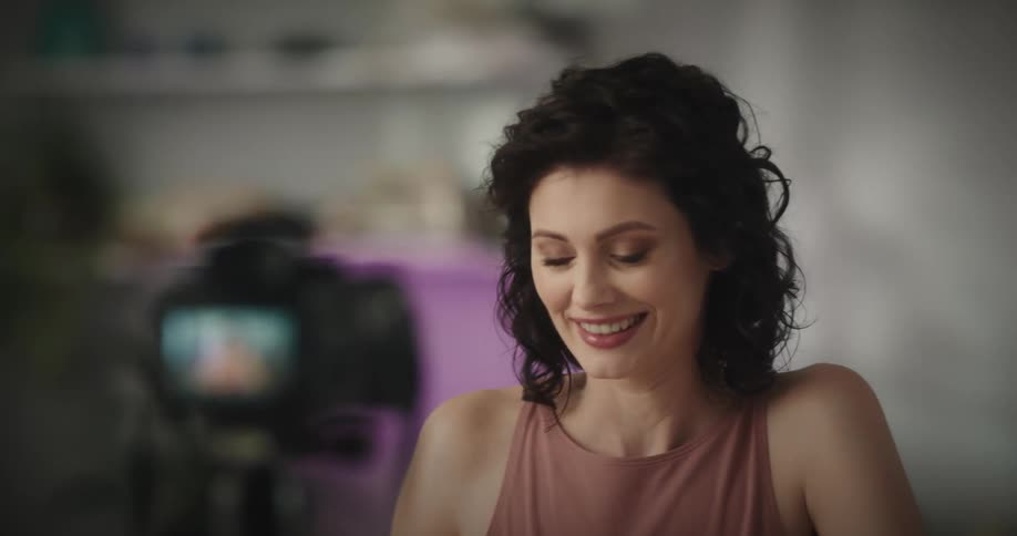 A woman is smiling and looking at a camera
