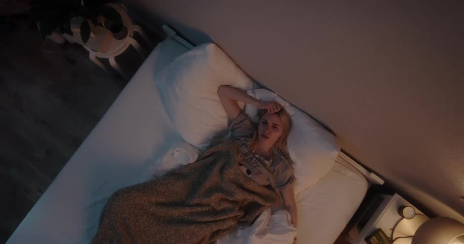 A woman is laying down in a bed