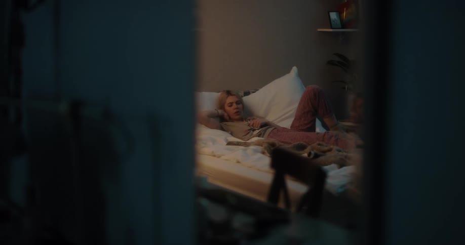 A woman is going to sleep in the bedroom