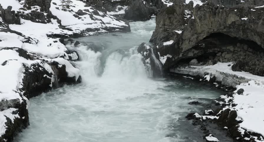 A river flowing through a snowy, rocky area