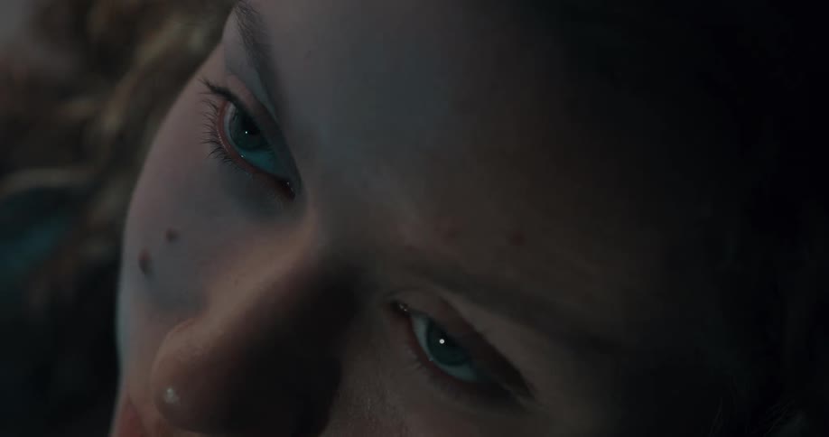 A woman looks forward blinking