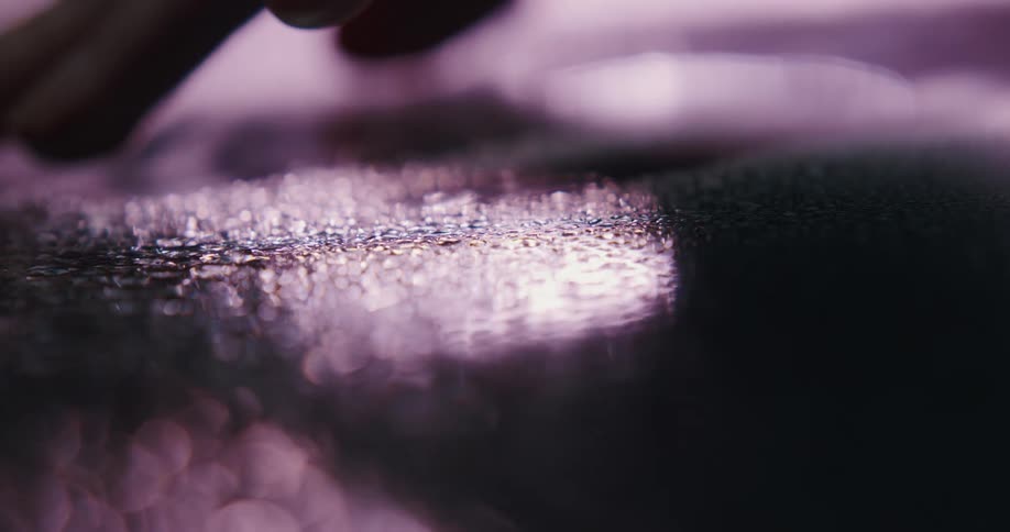 A person runs their fingers along the ground