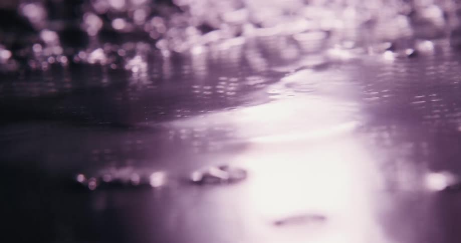 A flat surface is covered in a think layer of liquid that appears to be bubbling and sizzling