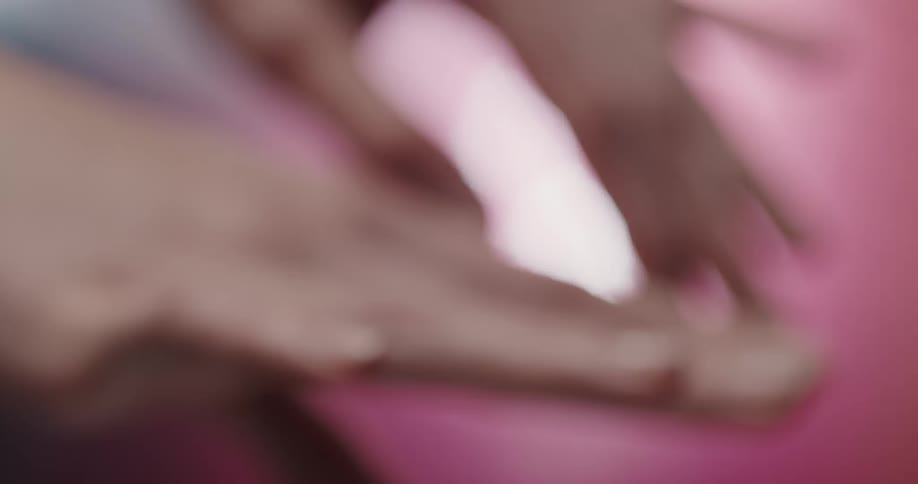 A persons hands and fingers moving up and down in front of a pink background
