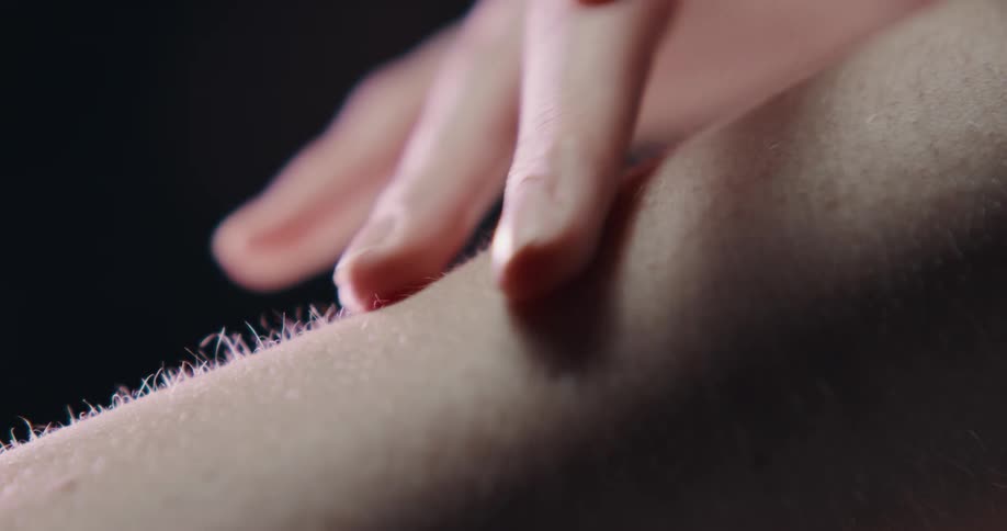 A woman caresses a mans arm