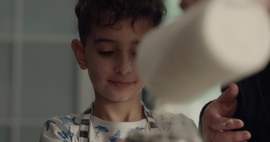 Son helps mother sift flour