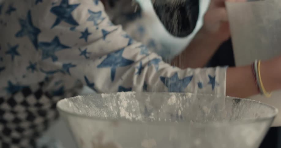 Mother and son sift flour as they smile and play