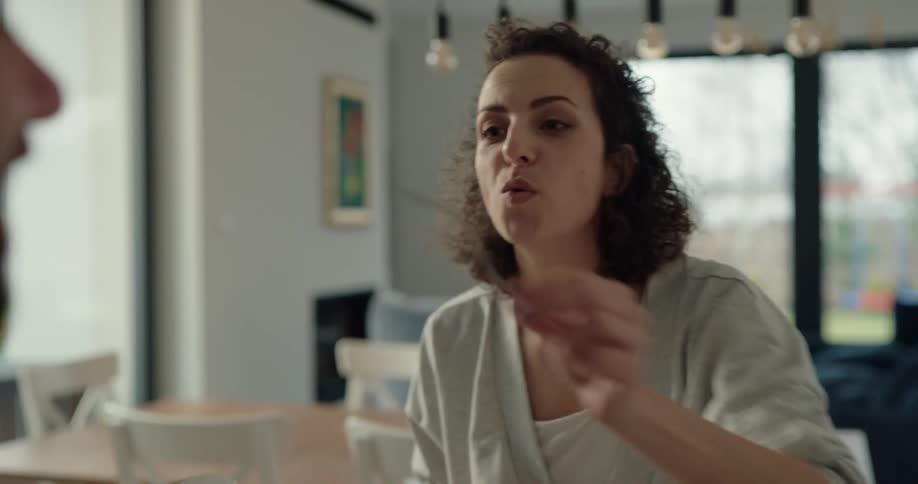A woman eats pancakes after having syrup poured on them