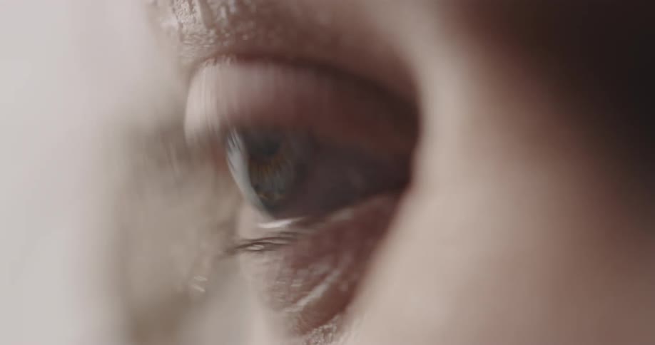 A woman blinks her eye as water droplets gather on her lashes