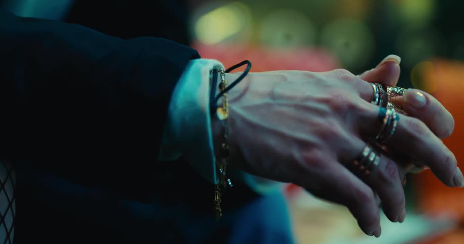 A man is wearing many rings