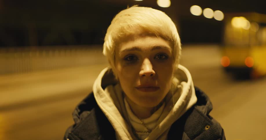 A girl walks down the street at night