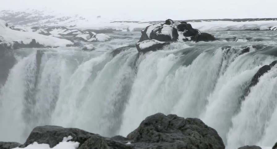 Viewing a waterfall surrounded by snow