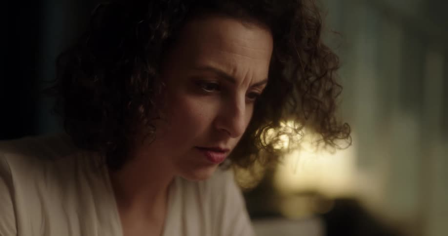 Woman frowns as she sits concentrating