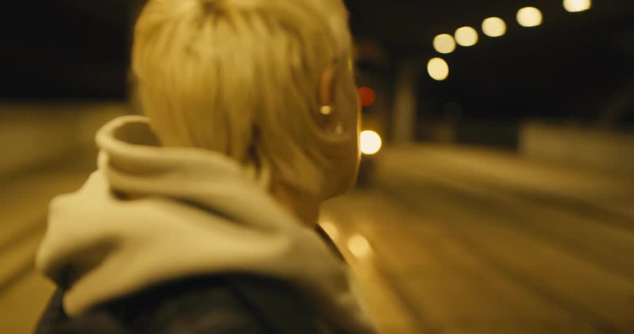 A woman is walking in a city at night