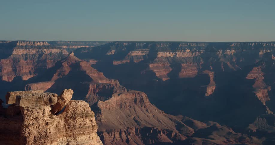 A vast canyon under a clear daytime sky