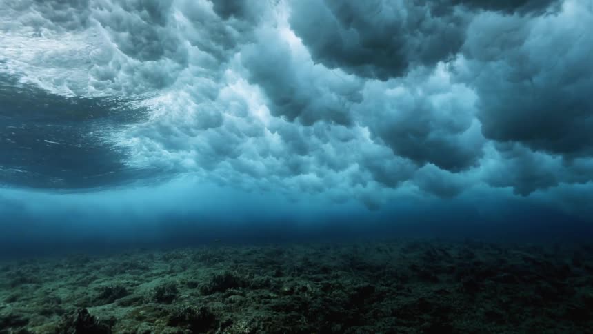 Crashing waves create clouds of bubbles underwater