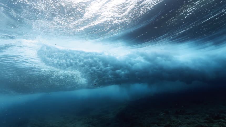 Underwater in the ocean with waves rolling on top
