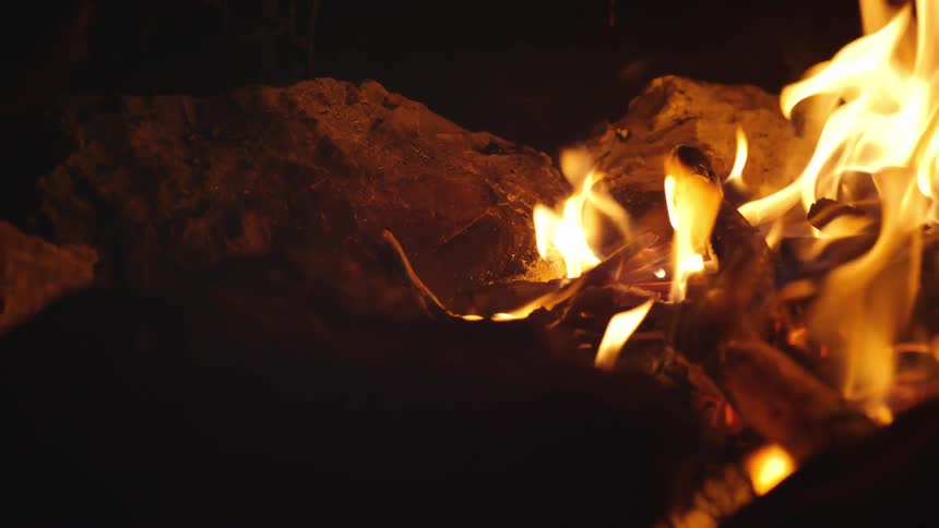 A campfire burns in the darkness