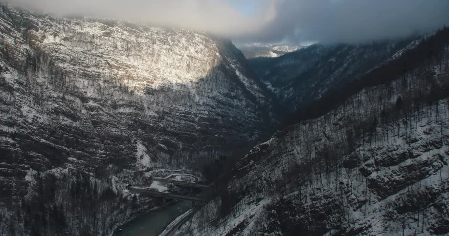 Snow covered forested mountains with a river valley below