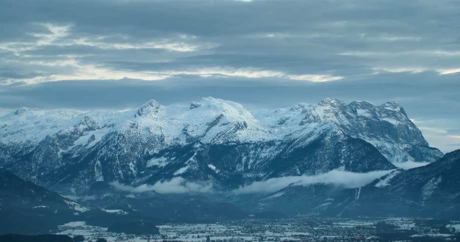 Snow covered mountain range under a cloudy sky