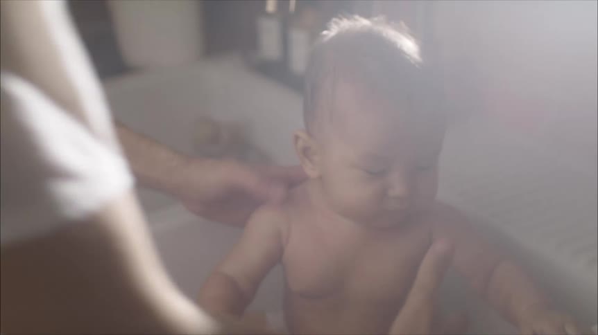 A mother washing her daughter in a sink