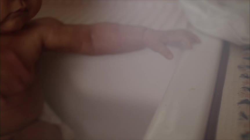 A woman bathing her baby in a sink