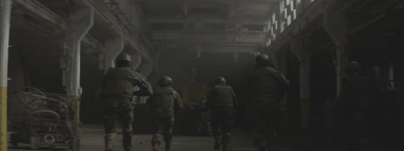 A military unit advances into a warehouse and takes cover