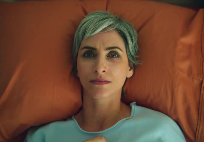 Young woman with short green hair resting on a bed open her eyes