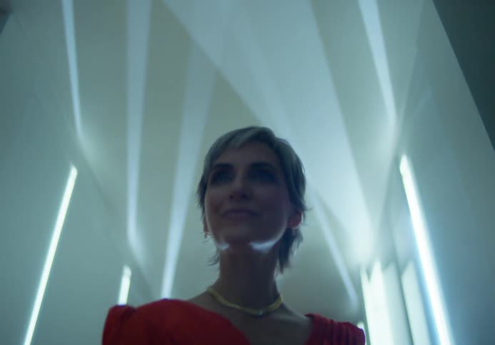 A woman posing in a red dress on a runway