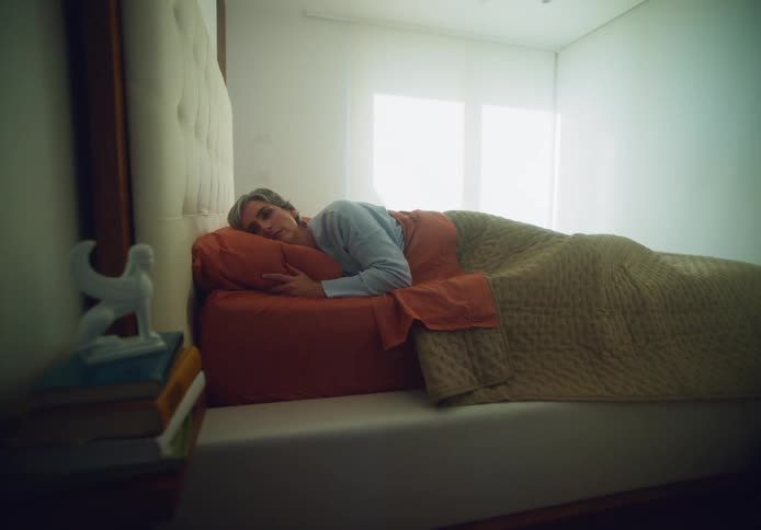 A person sleeping bed opens their eyes and adjusts on the pillow