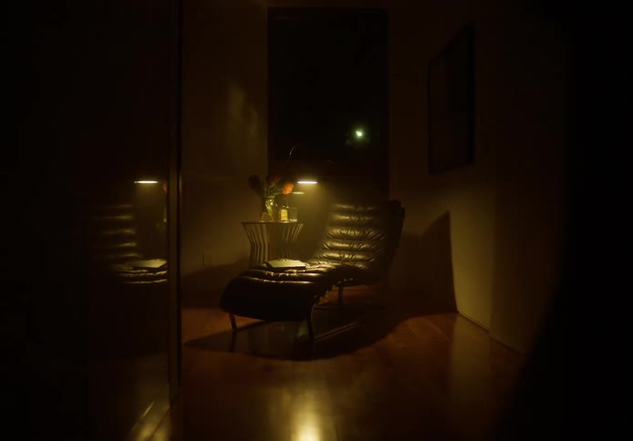 A woman reading a magazine in a lounge chair stands up and walks away