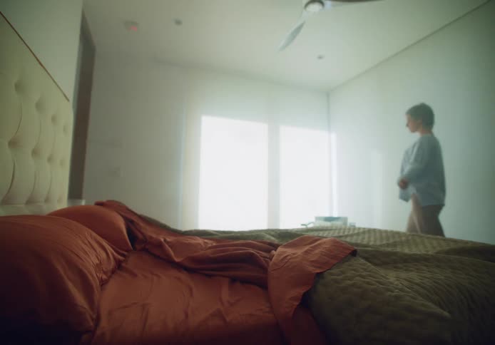 A woman is walking out of her bedroom during the day