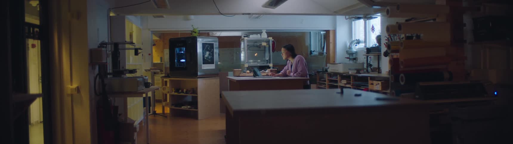 A woman is sitting in her kitchen with a laptop