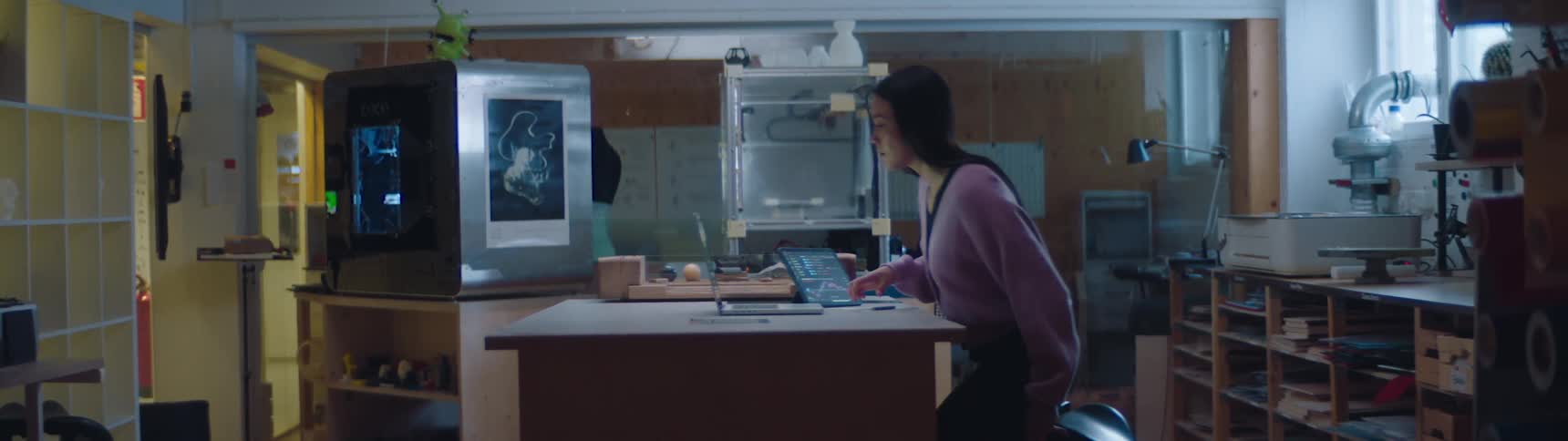A woman walks to the desk with her tablet
