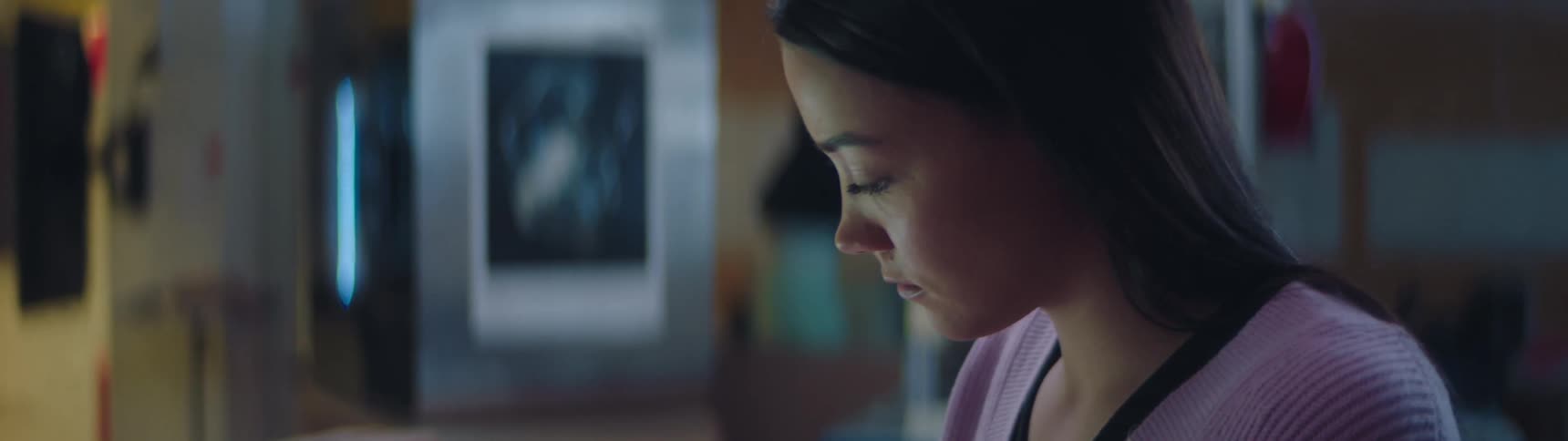 A woman is sitting in a classroom studying in the evening