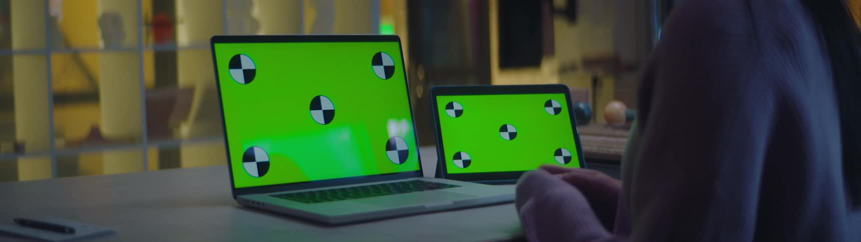 A person using a laptop and tablet at a desk