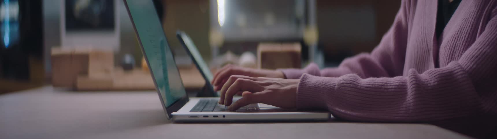 A woman is sitting at a desk and using a laptop