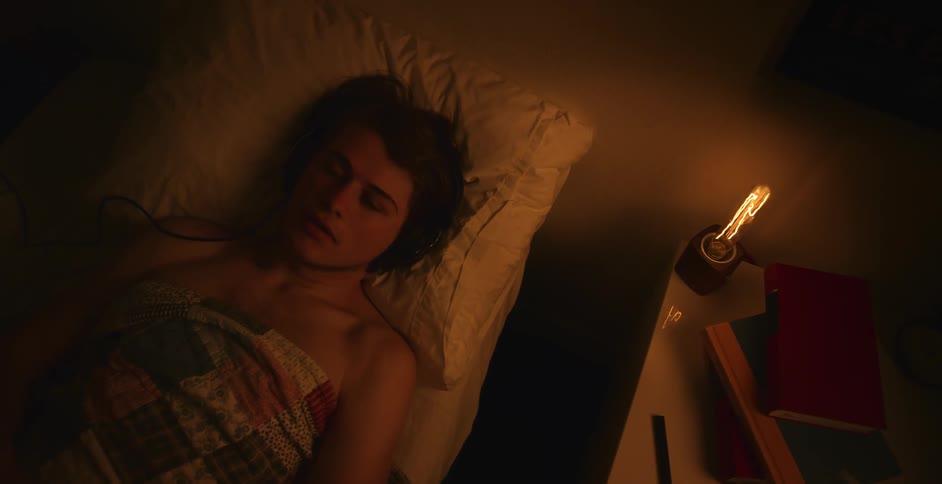 A man is putting on headphones and laying down