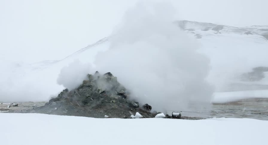 Steam is rising from rocks as it snows
