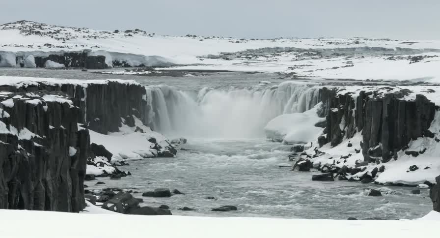 A waterfall is surrounded by ice and snow
