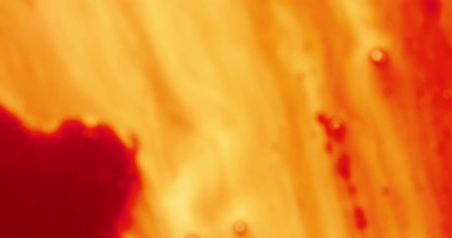 Flowing red and orange liquid with bubbles