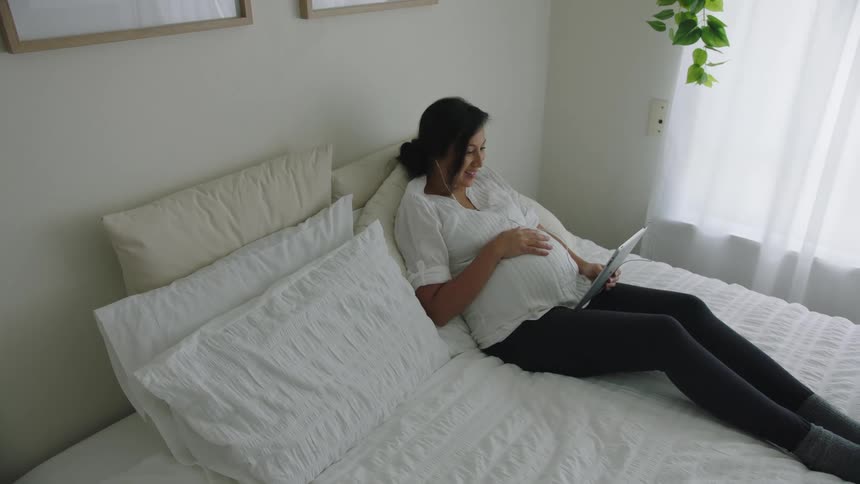 A woman is video chatting via laptop indoors